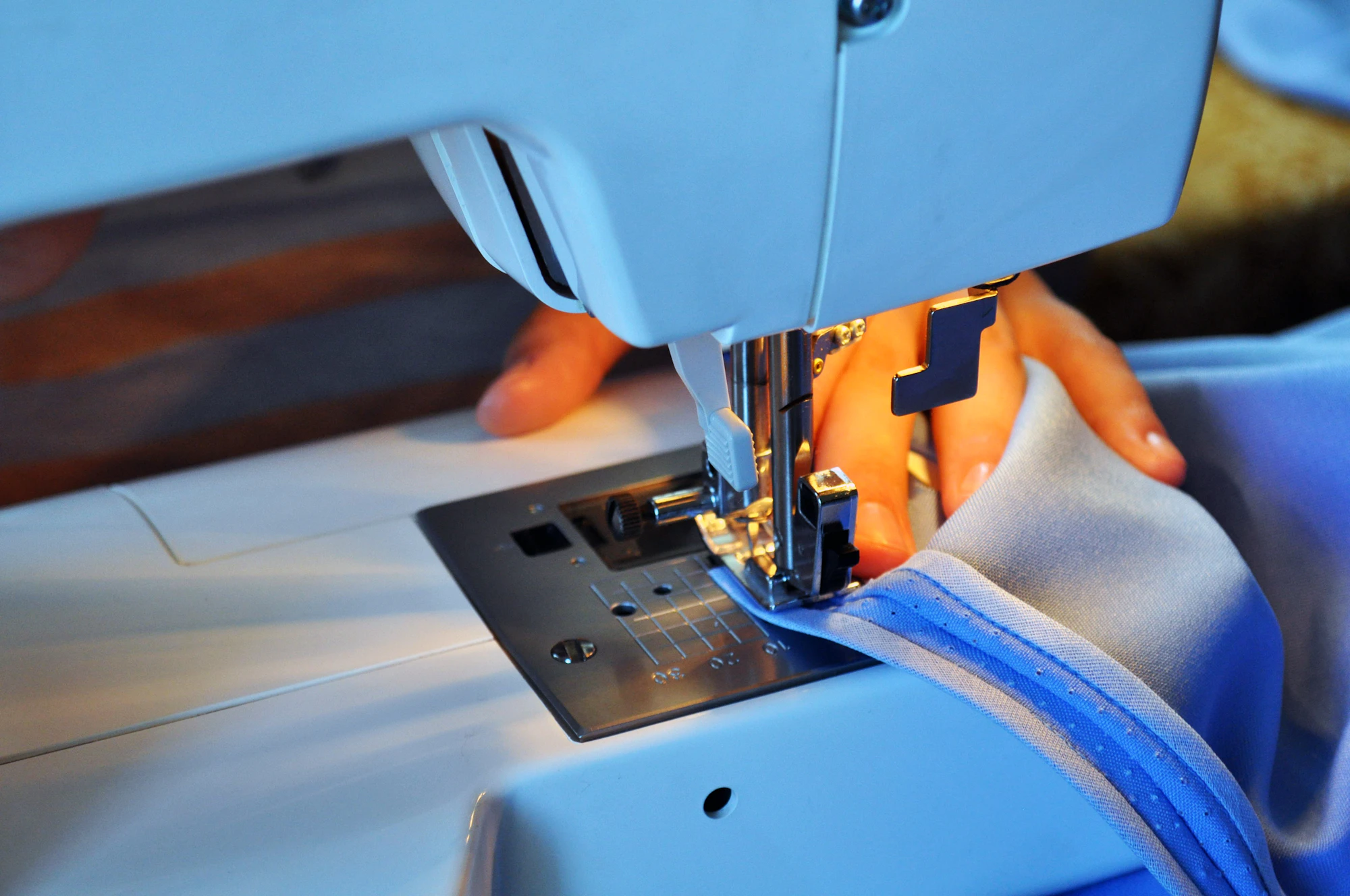 Editorial inspiration: hands guiding fabric through a sewing machine